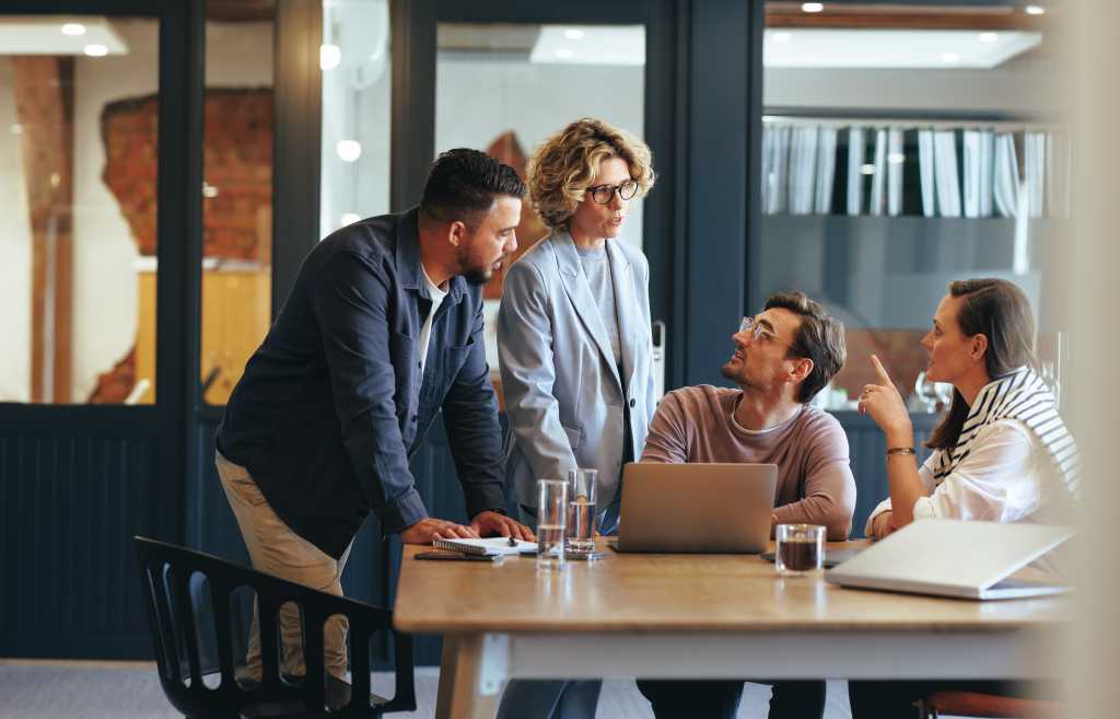 Business people having a meeting in a digital marketing agency. Group of business professionals discussing a project in an office. Teamwork and collaboration in a creative workplace.