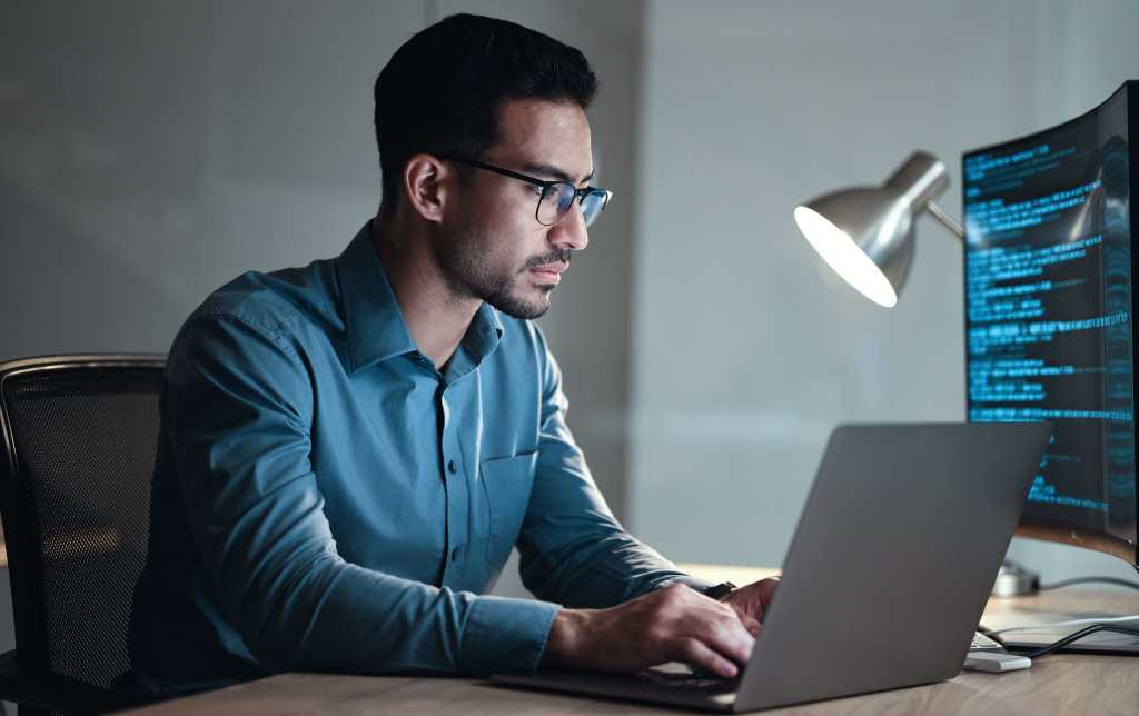 Laptop, screen and business man for coding, software development and programming script in cybersecurity. Night, computer research and programmer or IT person with html code, system or data analysis