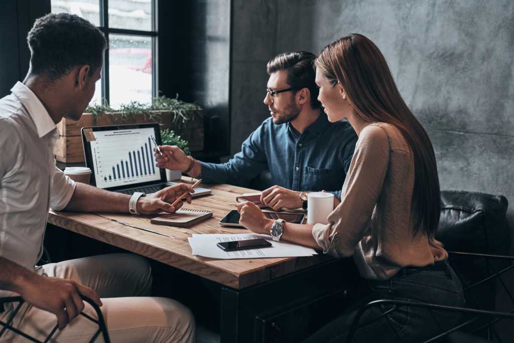 Business professionals. Group of young confident business people analyzing data using computer while spending time in the office