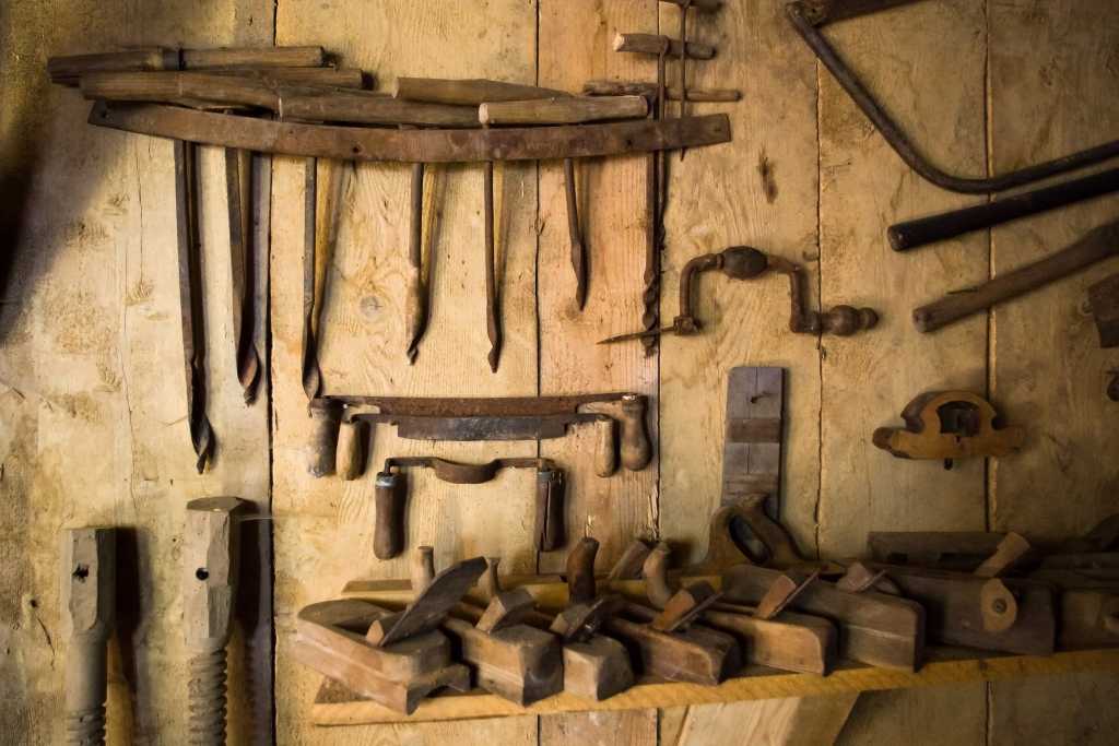 shutterstock 77260183 rusty old woodworking tools on the wall of an old workshop