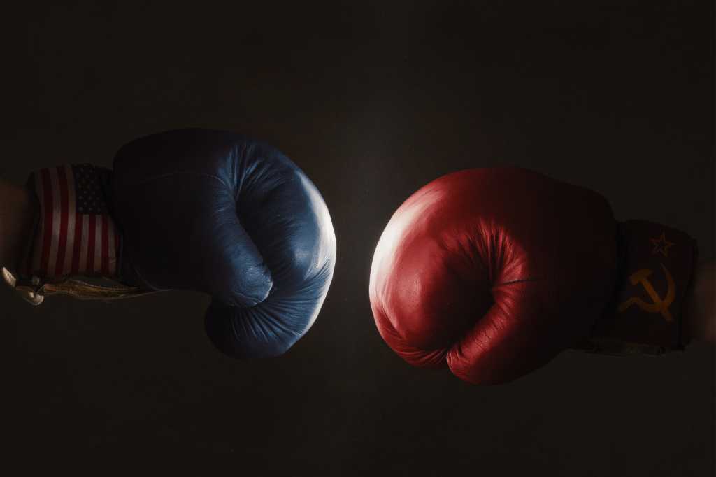 blue and red boxing gloves face off against a black background