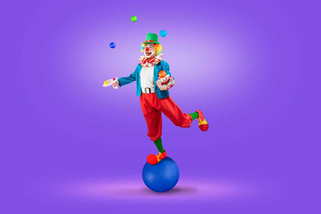 colorfully dressed juggler clown juggling brightly colored blue green red yellow balls against a bright purple background